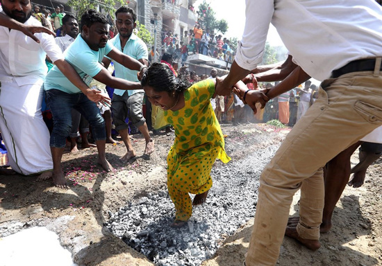 کمک به زن هندی برای راه رفتن روی زغال داغ